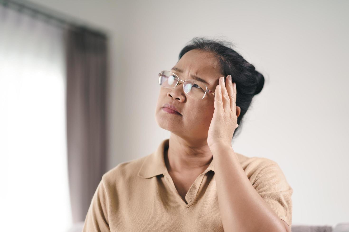 exausto, cansado, deprimido, estressado, pensativo, maduro, sênior, mulher, sofrendo de dores de cabeça, doenças cerebrais, problemas mentais, conceito de Alzheimer. foto