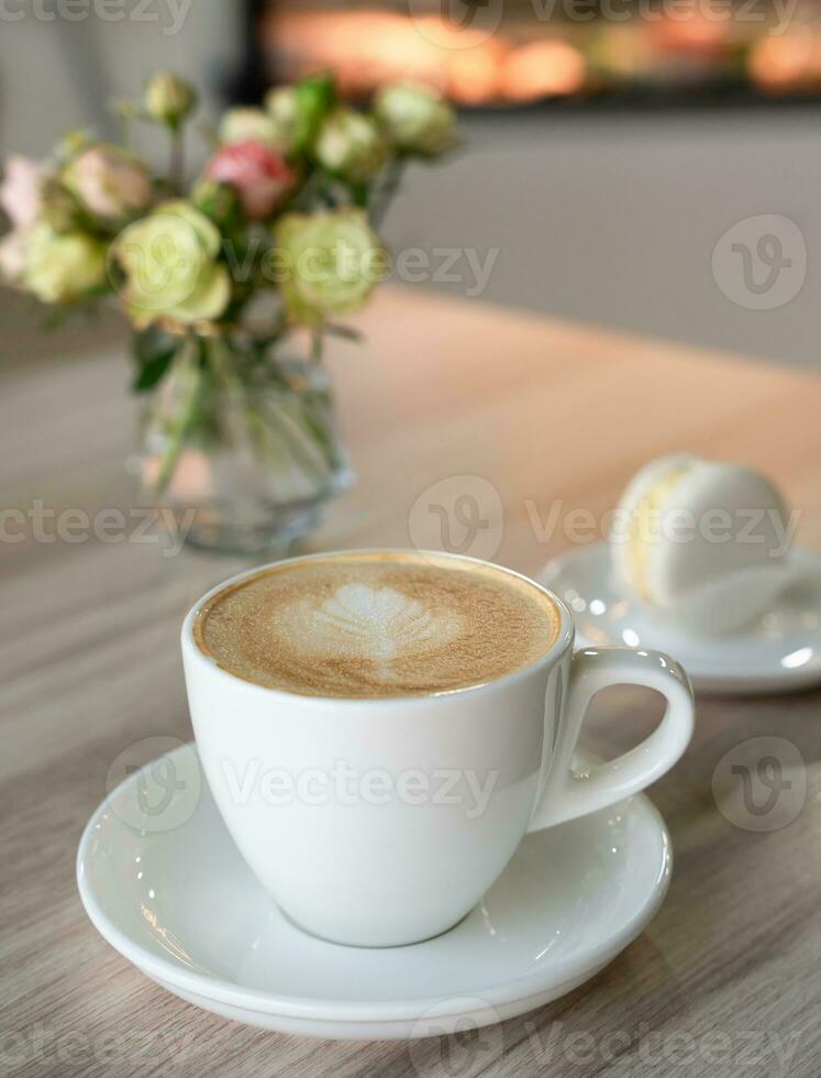 uma copo do fresco aromático cappuccino e macaron em uma comprimido a cafeteria. seletivo foco. foto