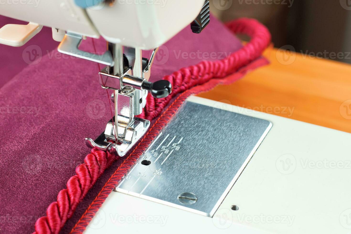 de costura máquina. a processo do de costura uma decorativo cordão do vermelho tecido. foto
