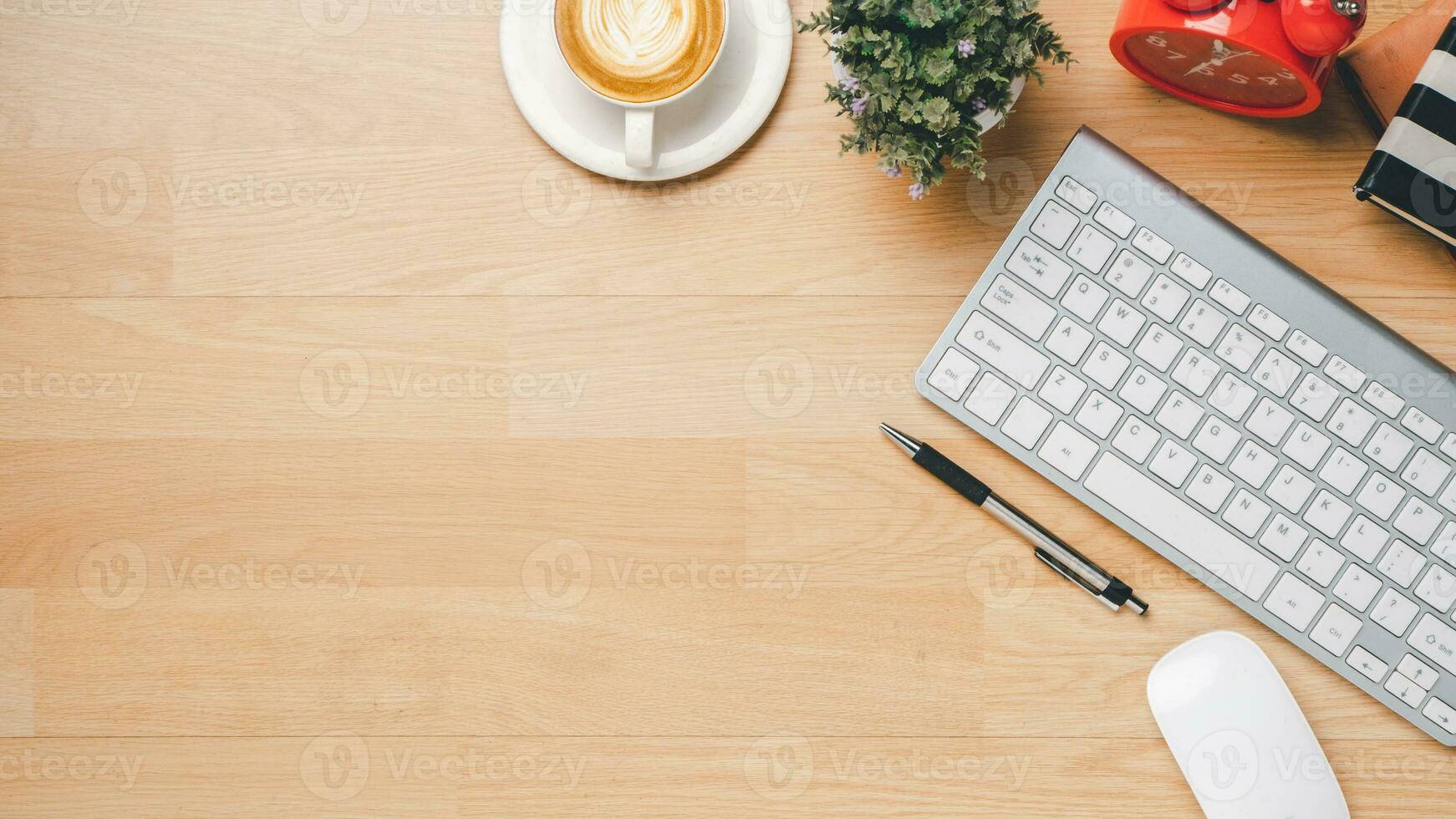 escritório de madeira escrivaninha com teclado, caderno, caneta, rato e copo do café, topo Visão com cópia de espaço, plano deitar. foto