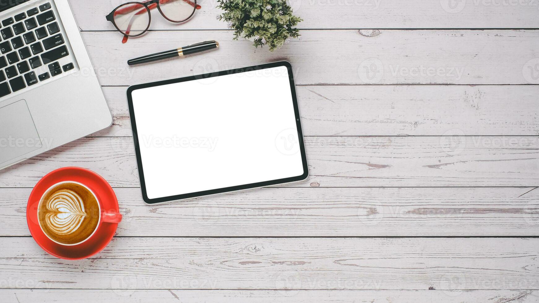 branco de madeira escrivaninha local de trabalho com em branco tela tábua, computador portátil, caneta, óculos e copo do café, topo Visão plano deitar com cópia de espaço. foto