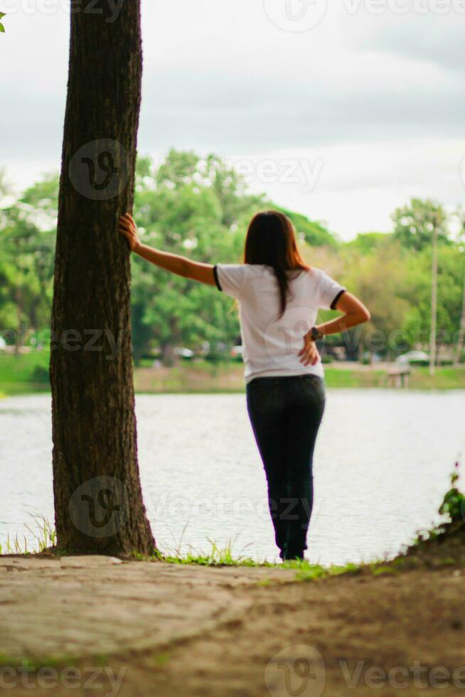 a jovem mulher carrinhos sozinho em a sacada do a montanha apresentar dentro a manhã para Assistir a Sol subir com solidão. uma jovem mulher viajante universo em pé sozinho dentro solidão de uma reservatório. foto