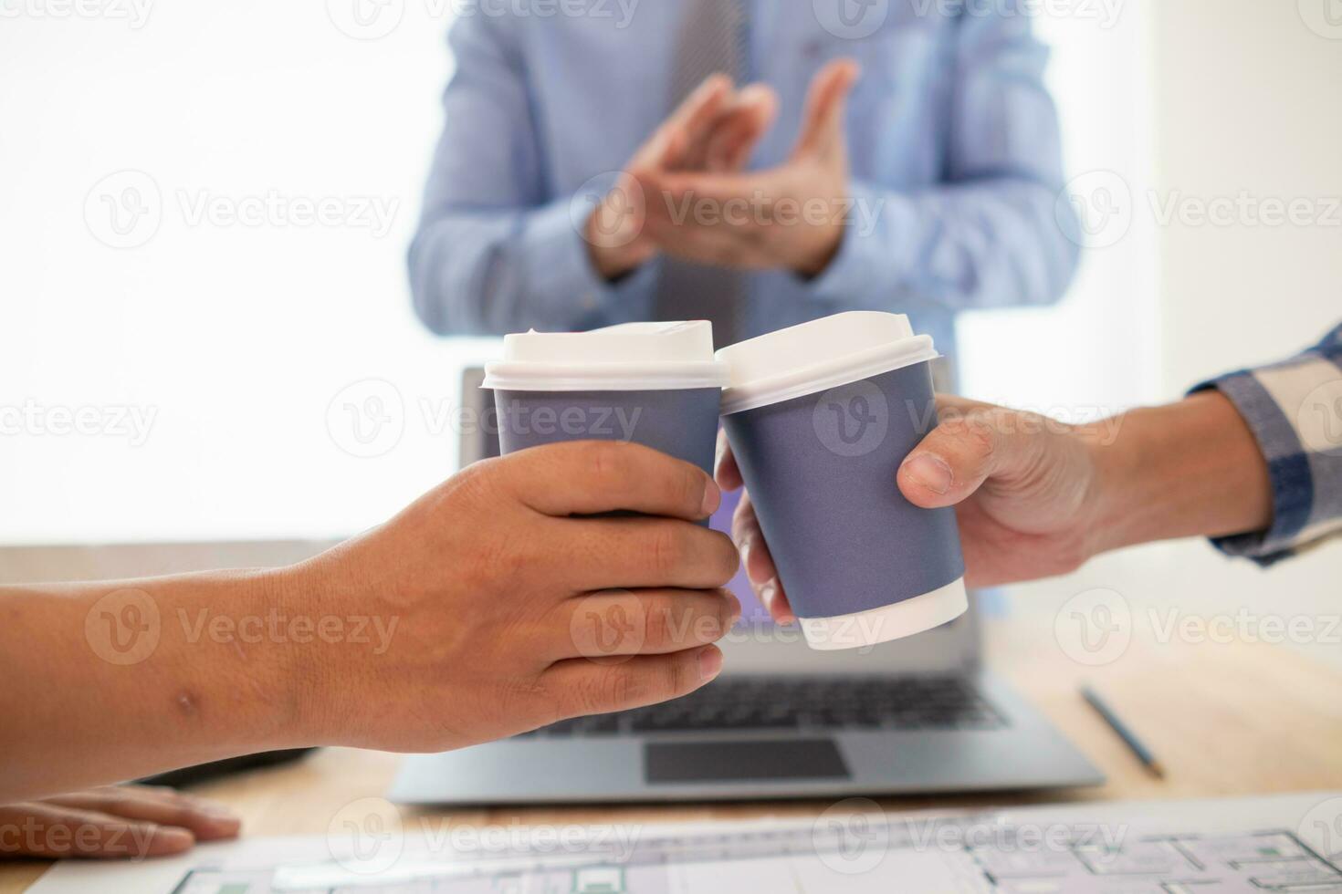 equipes engenheiros, arquitetos e real Estado investidores agitado sobre copo do quente café para felicitar eles seus bem sucedido projeto Projeto dentro orçamento. quente café choque conceito para comemoro dentro escritório foto