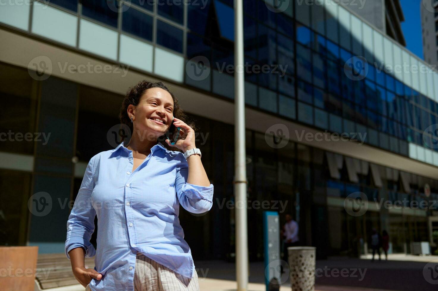 confiante autêntico profissional retrato do uma com propósito empresária, empreendedor falando em dela inteligente Móvel telefone foto