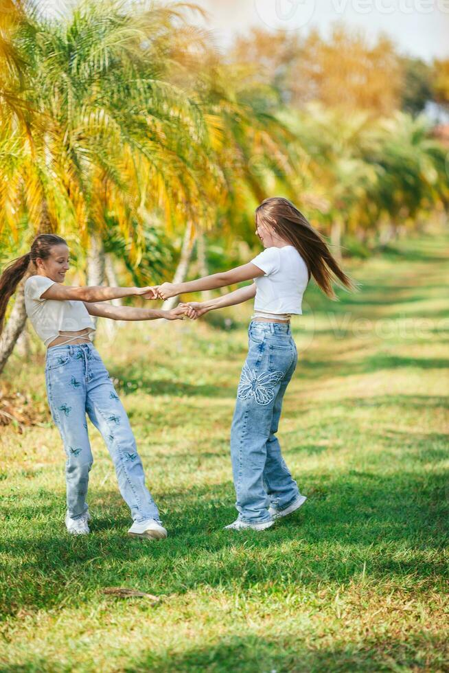 dois meninas dentro jeans dentro uma campo com Palma árvores foto