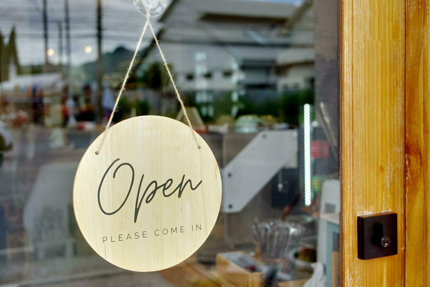 circular placa pendurado em a vidro porta do a café fazer compras dizendo aberto por favor venha dentro foto