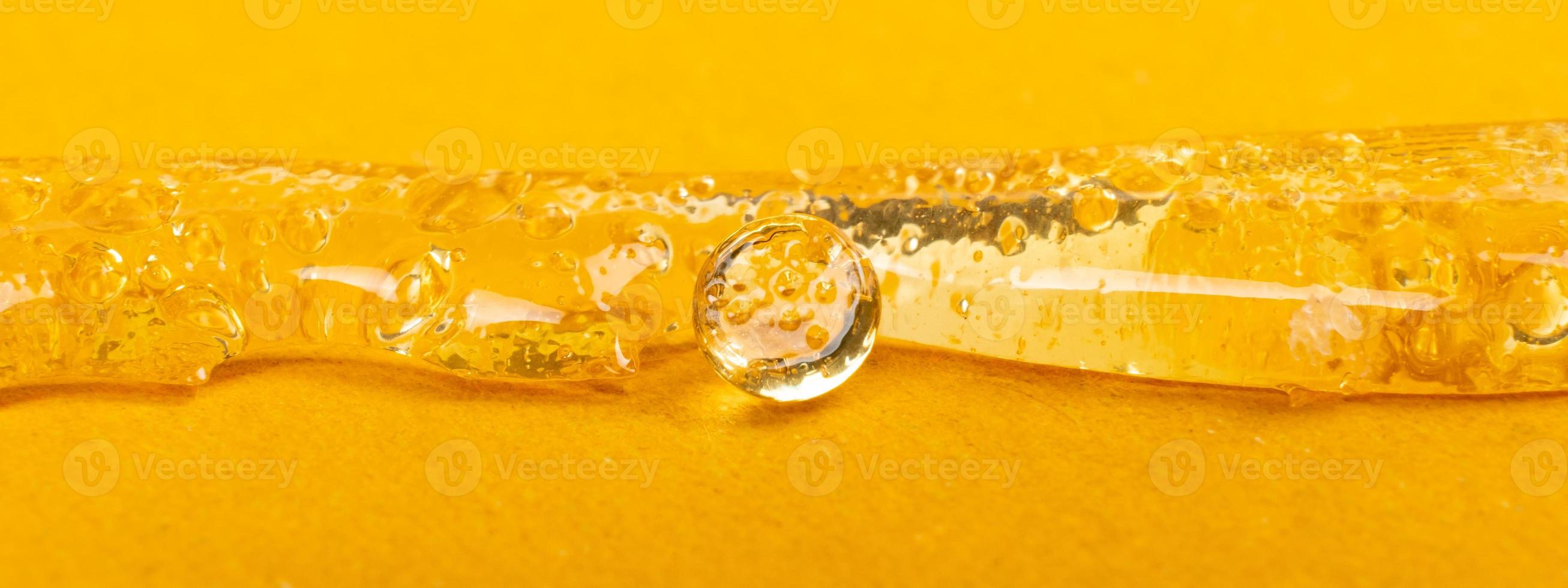 cera de maconha pura e transparente em fundo amarelo, textura dab de cannabis foto