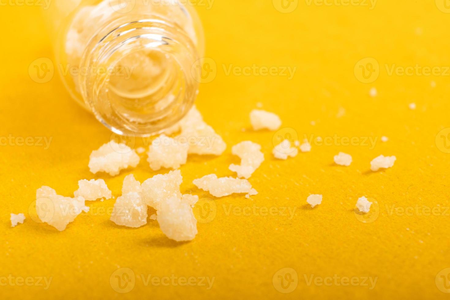 cristais de sal narcótico anfetamina em fundo amarelo foto