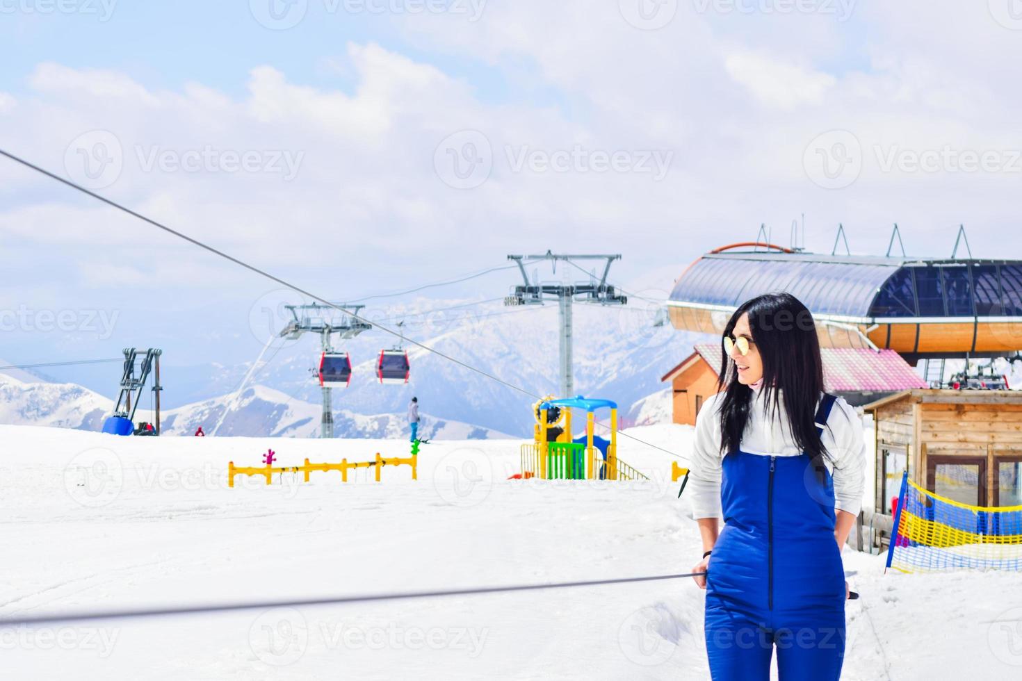 Retrato de esquiadores de mulher caucasiana no elevador de bebê aprendendo a esquiar foto