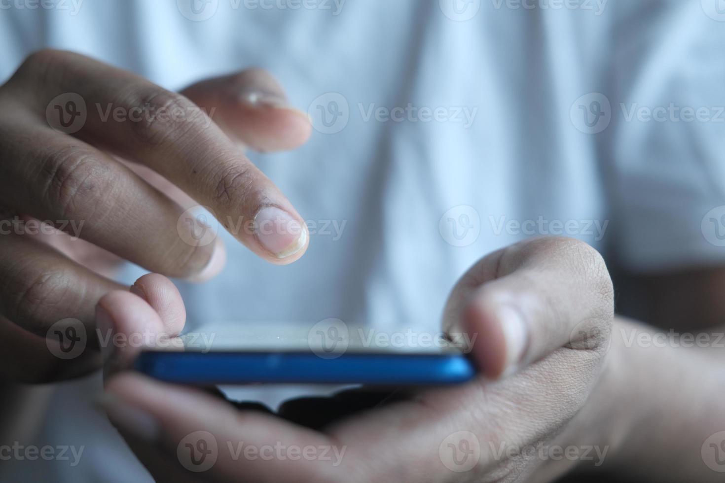 close-up da mão do jovem usando telefone inteligente. foto