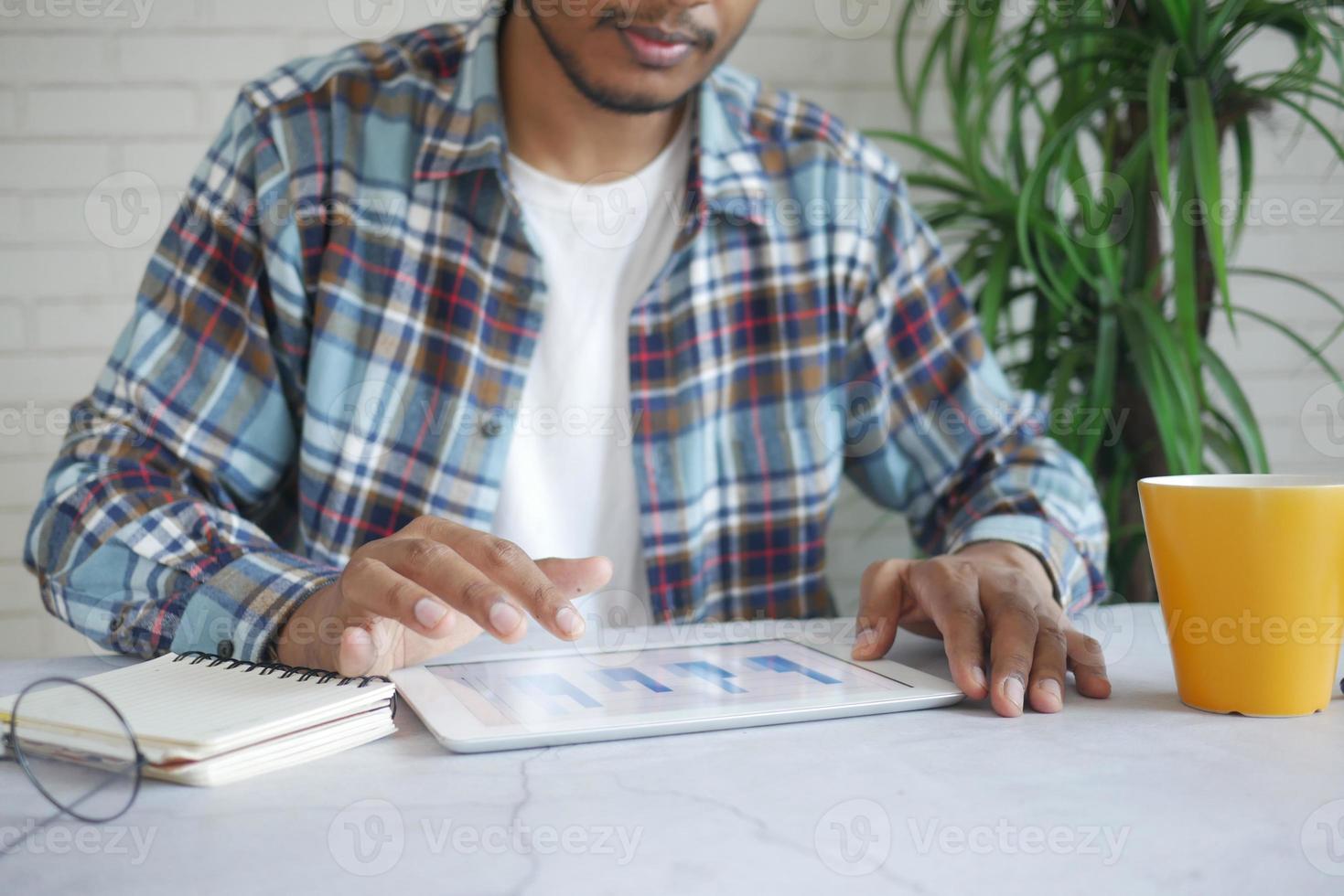 mão do jovem com caneta analisando o gráfico de barras em papel branco foto