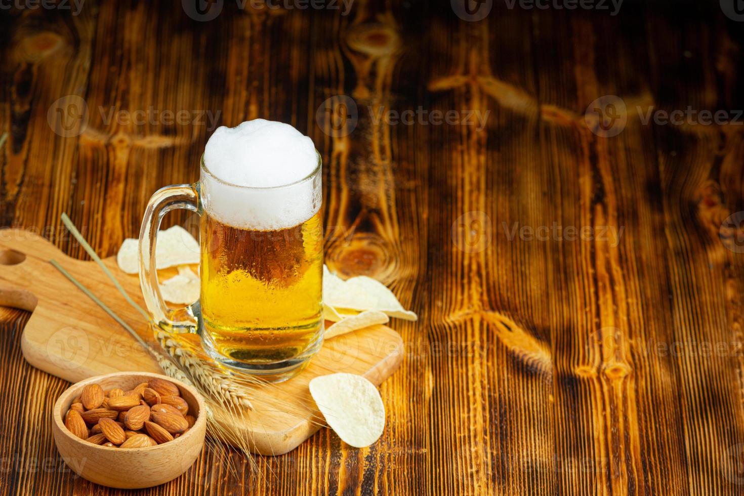 um copo de cerveja é colocado no chão de madeira. foto