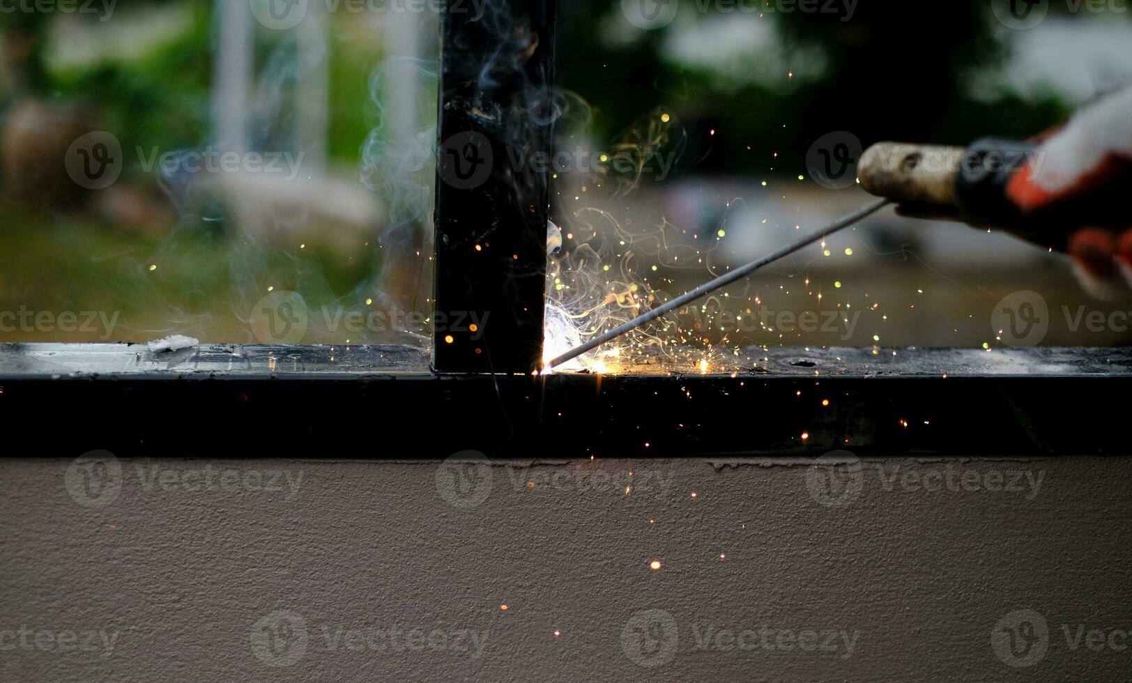 técnico de soldagem está soldando aço com faíscas foto