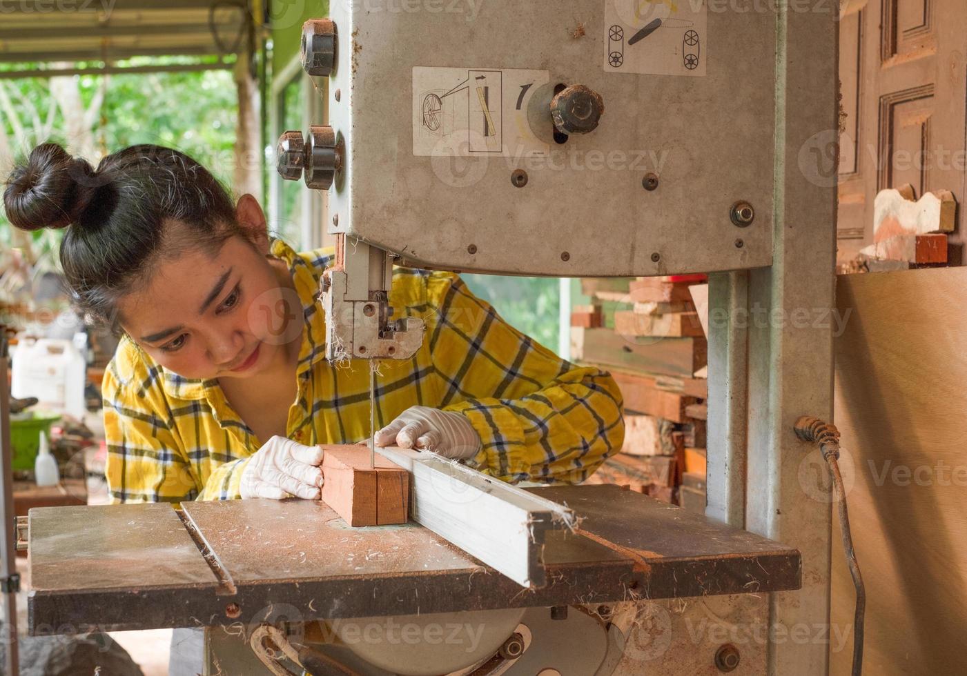 mulheres em pé é artesanato, corte de madeira em uma bancada de trabalho foto