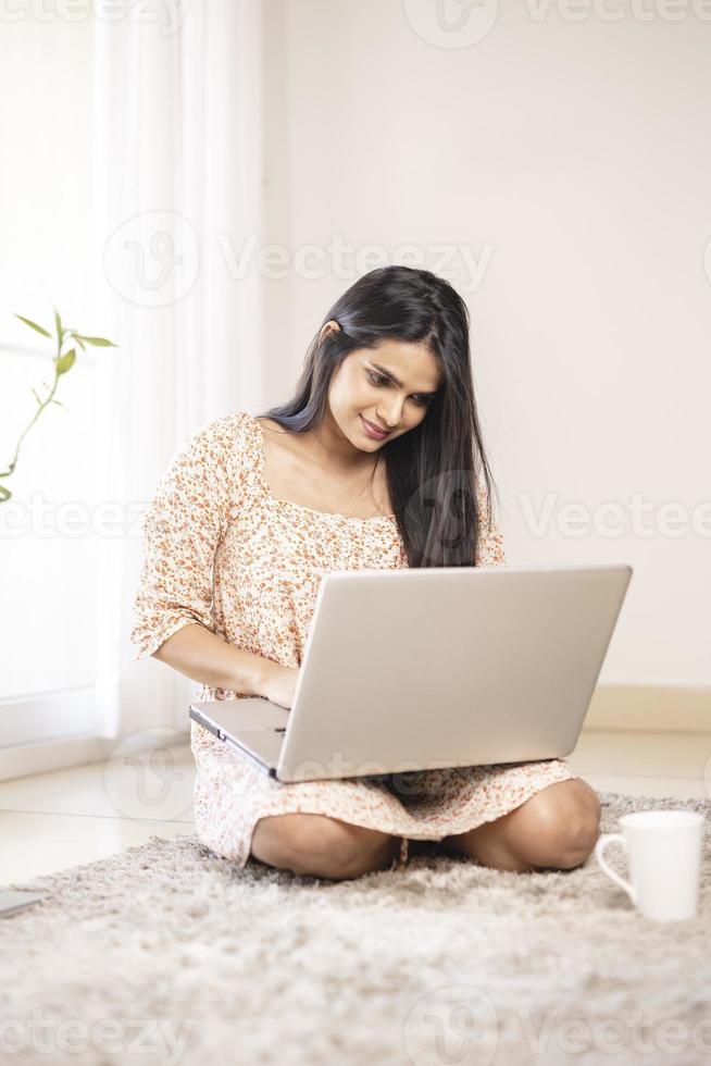 linda jovem indiana usando laptop em casa foto