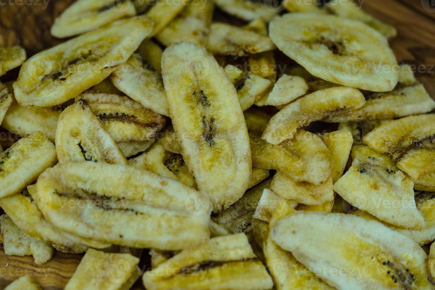 lascas de banana secas em madeira de oliveira foto