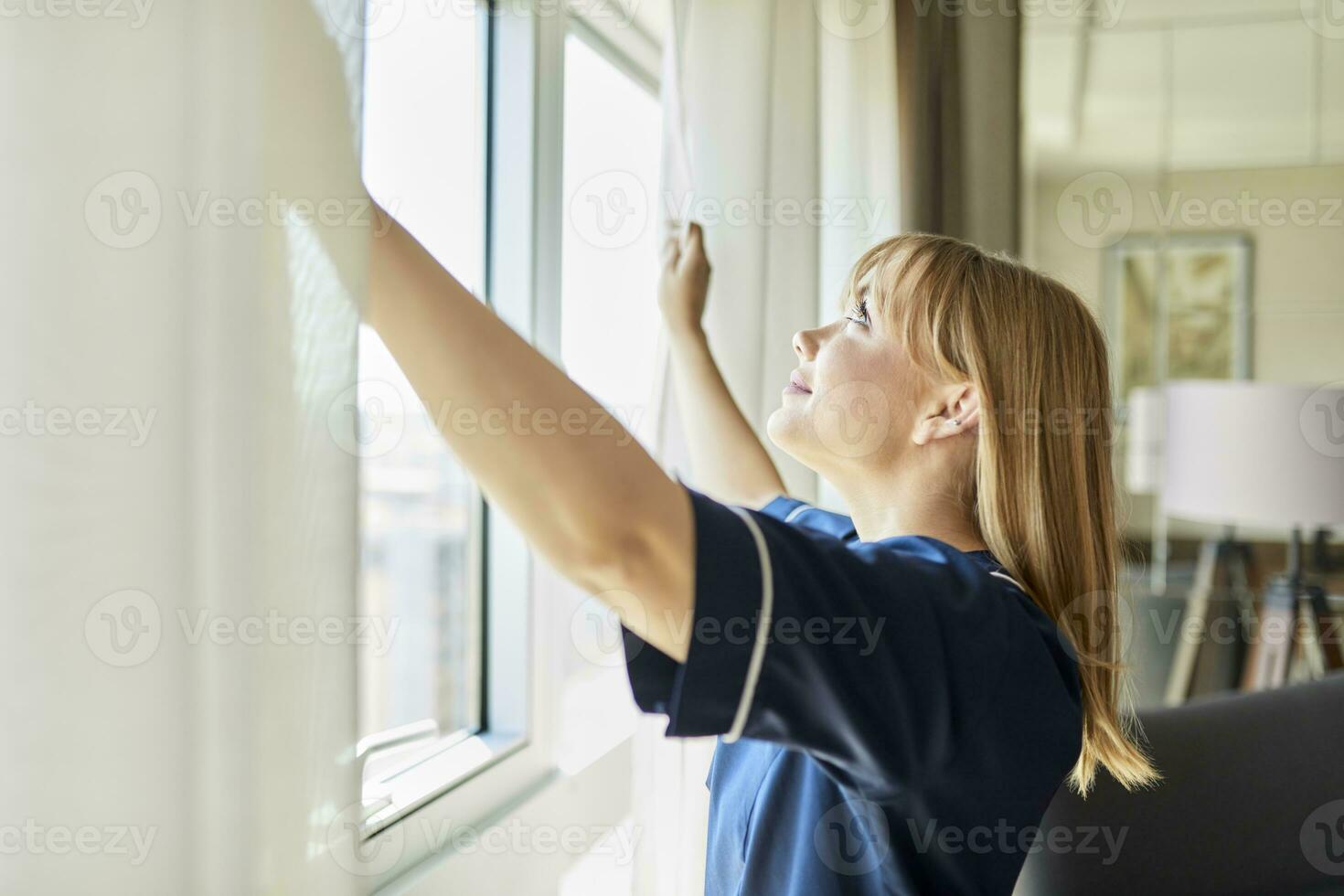 sorridente camareira abertura cortinas do janela dentro hotel quarto foto