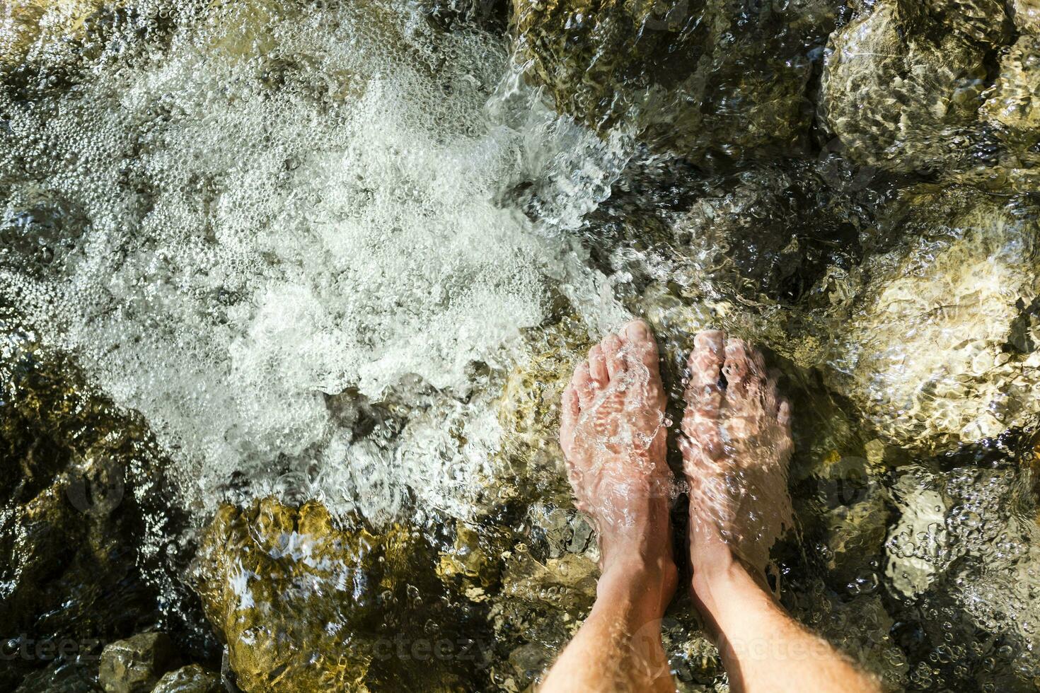 do homem pés em pé em pedra dentro uma Ribeiro foto