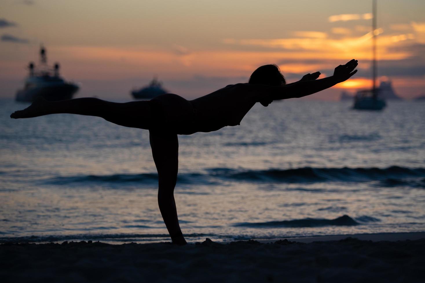 silhueta do modelo de fitness fazendo ioga ao pôr do sol foto
