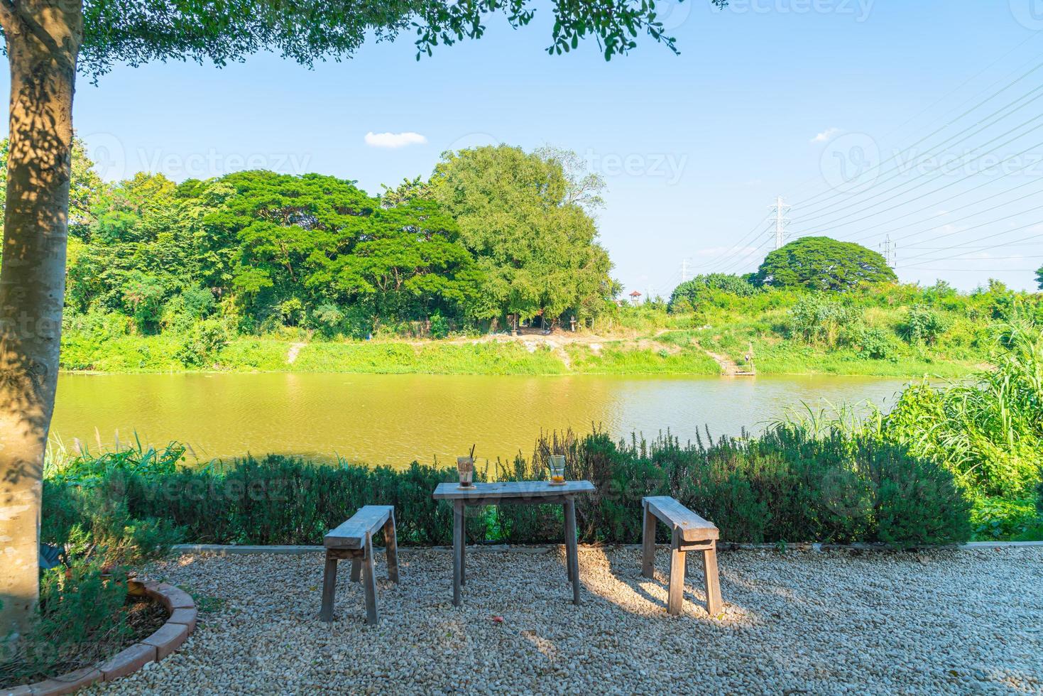 mesa e cadeira vazias com vista para o rio em cafeteria e restaurante foto