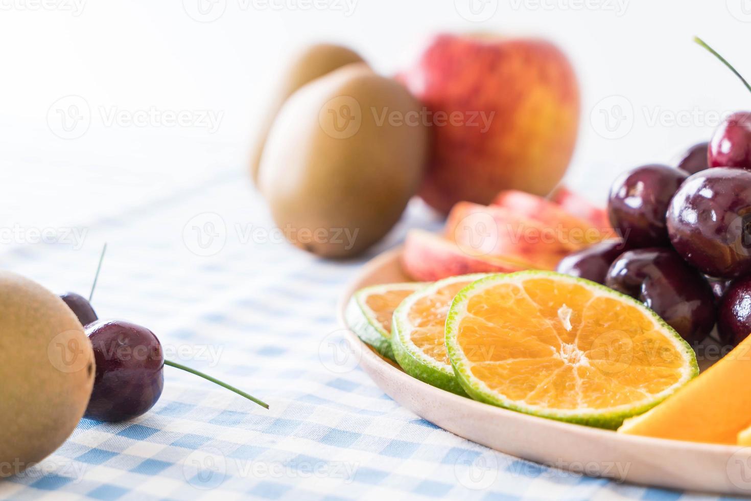 Misto de frutas fatiadas em tigela de madeira foto