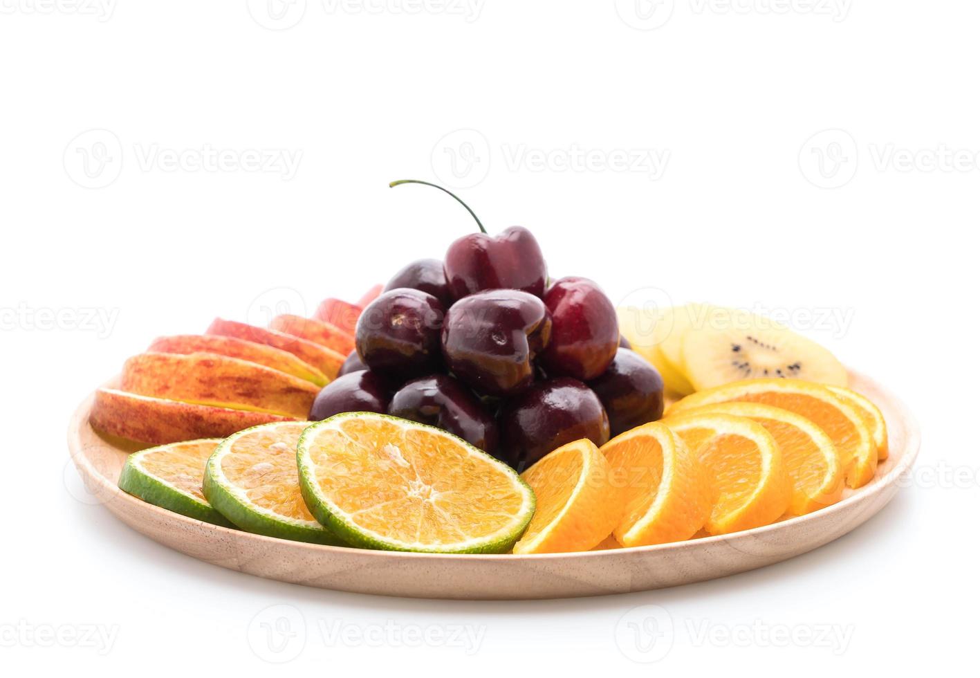 Misto de frutas fatiadas em tigela de madeira foto