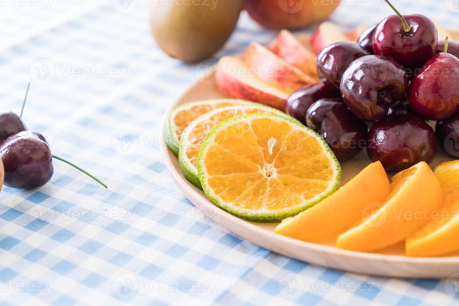 Misto de frutas fatiadas em tigela de madeira foto