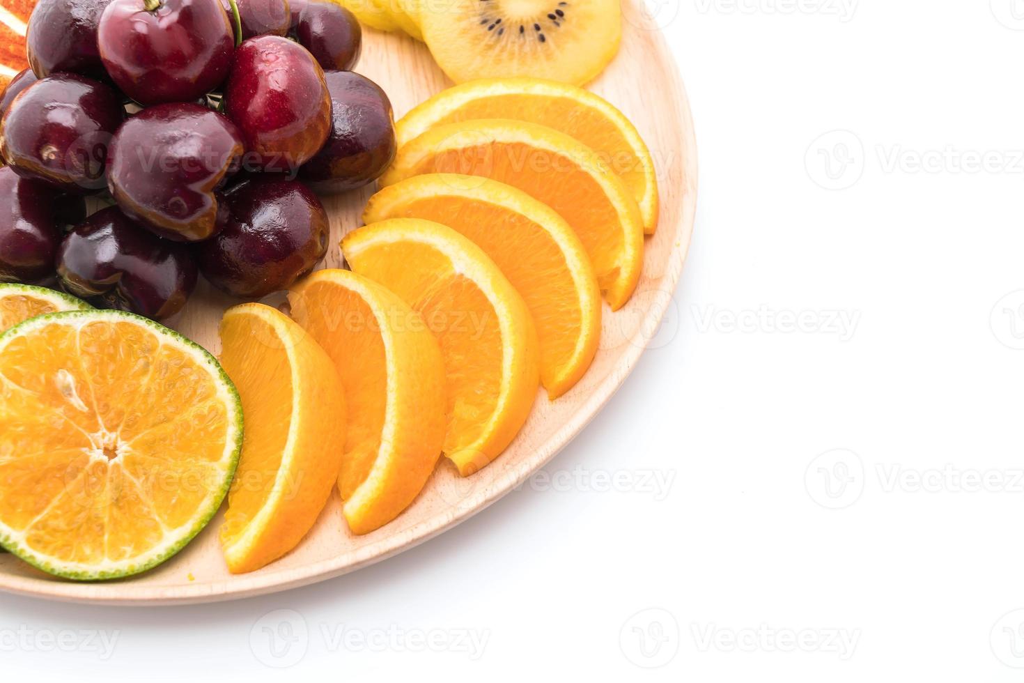 Misto de frutas fatiadas em tigela de madeira foto