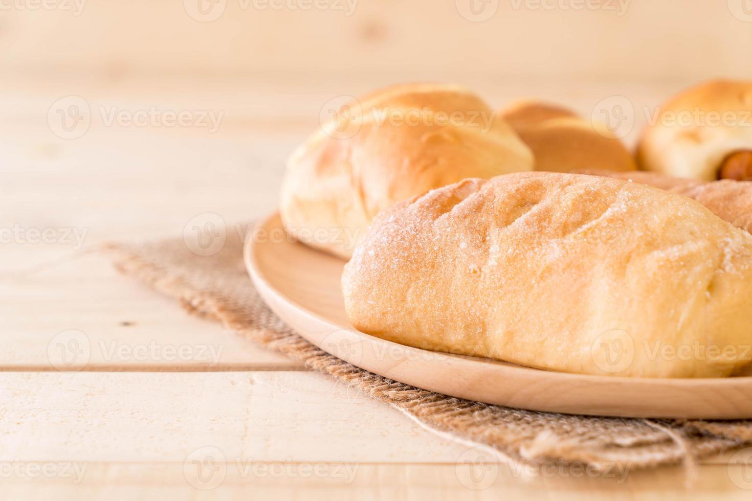 pão em prato de madeira sobre a mesa foto