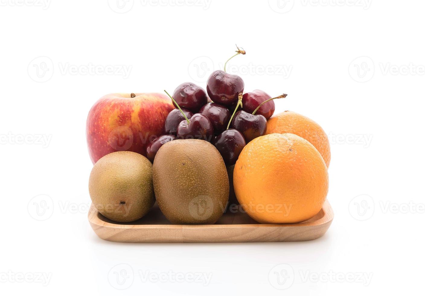 frutas misturadas em placa de madeira no fundo branco foto