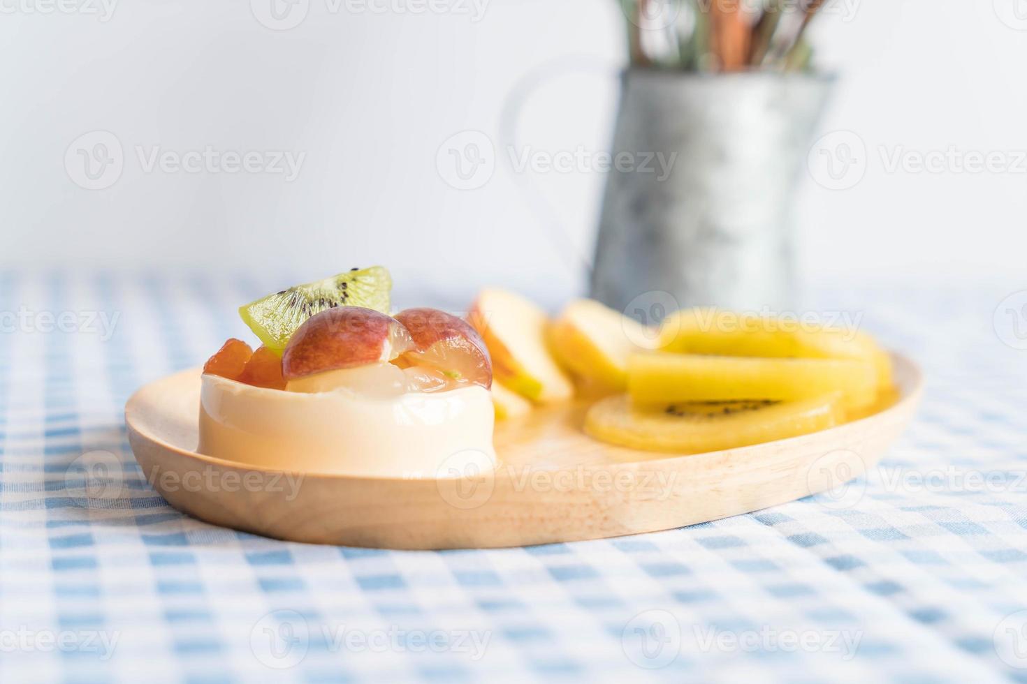 Pudim de frutas com kiwi e maçã na mesa foto