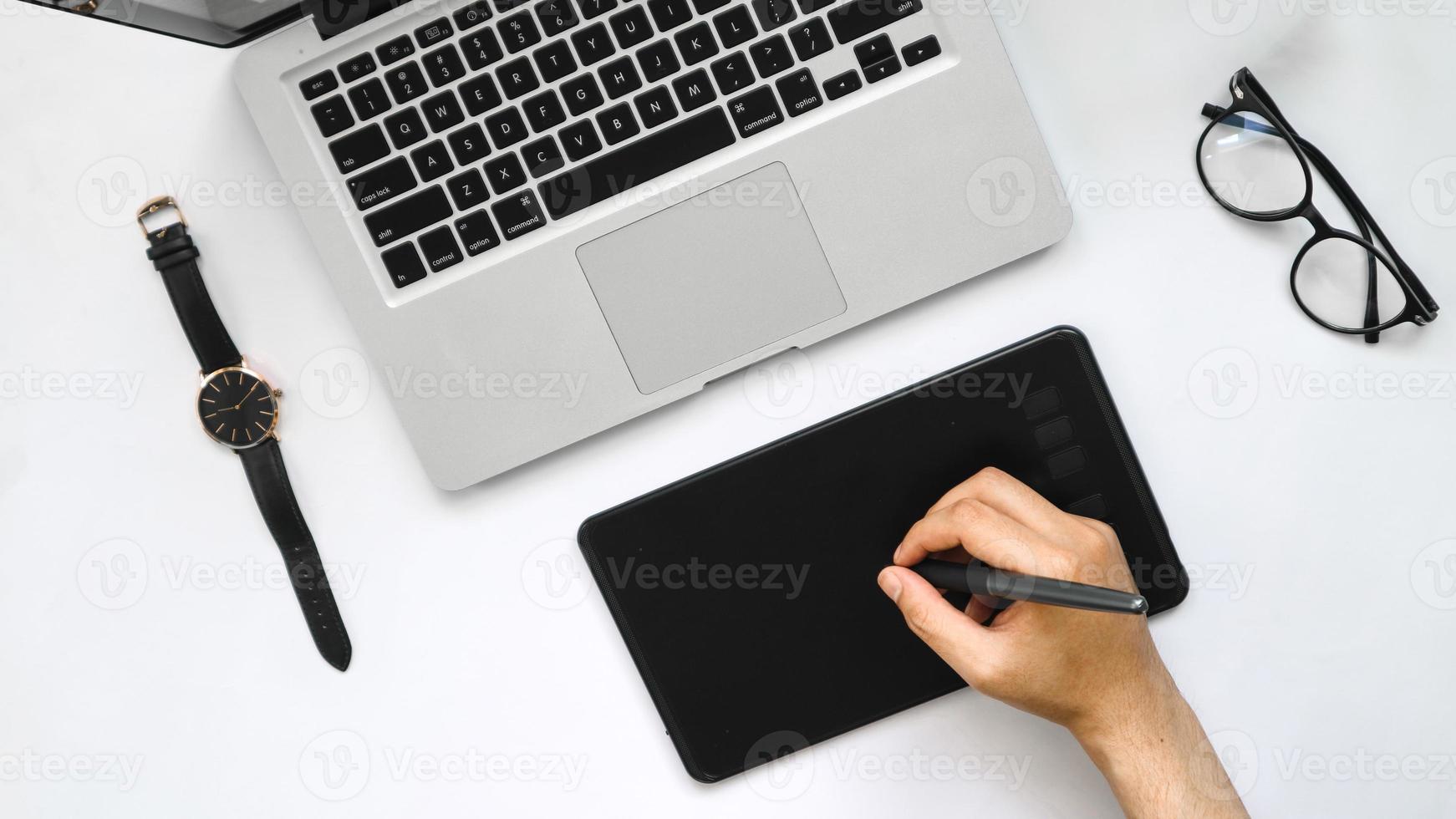 visualização de mesa de laptop, pen tablet e relógio de pulso em fundo branco foto