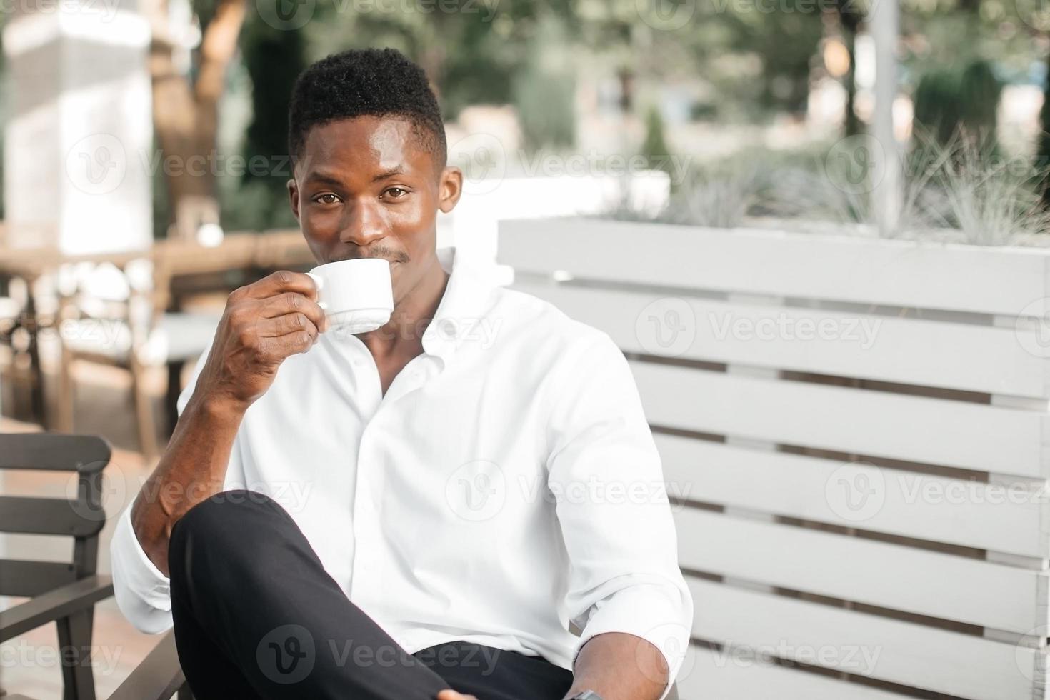 empresário afro-americano, trabalha em um laptop em um café, freelancer foto