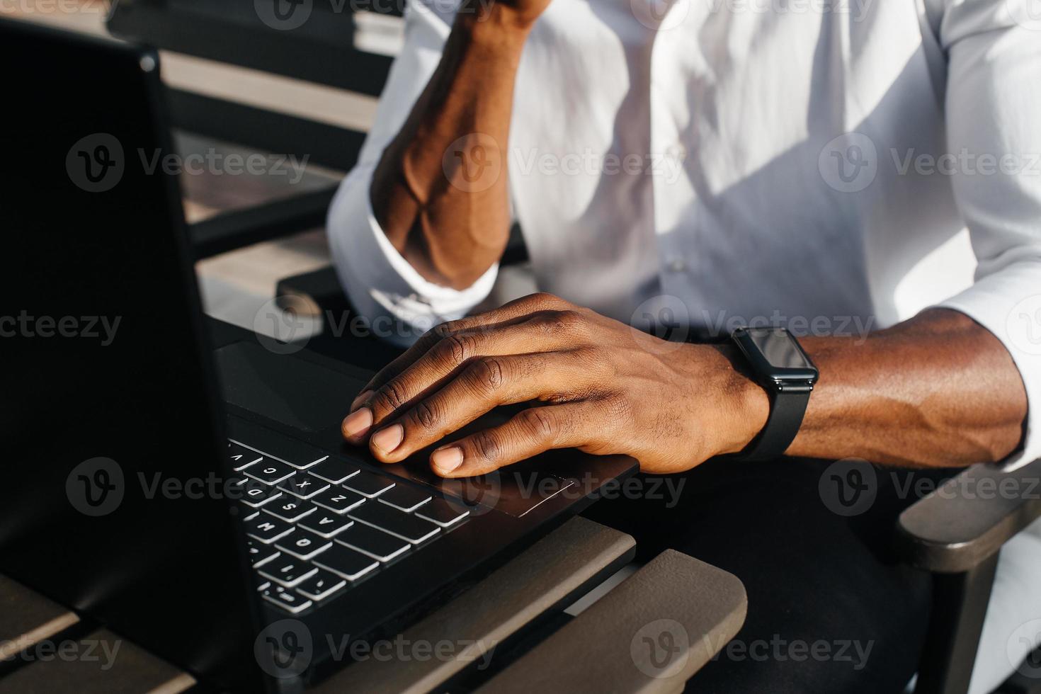 empresário afro-americano, trabalha em um laptop em um café, freelancer foto