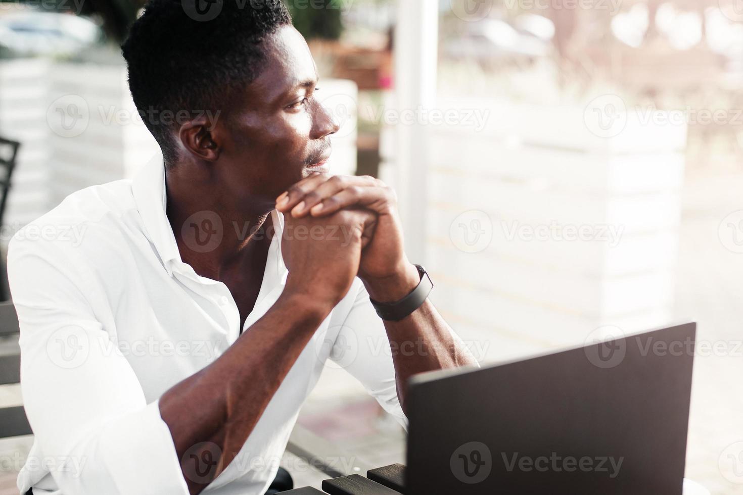 empresário afro-americano, trabalha em um laptop em um café, freelancer foto