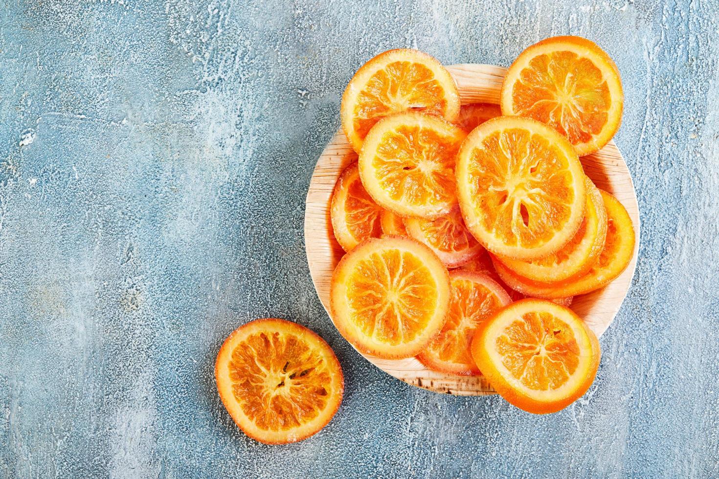 fatias de laranjas ou tangerinas secas em um prato de madeira foto