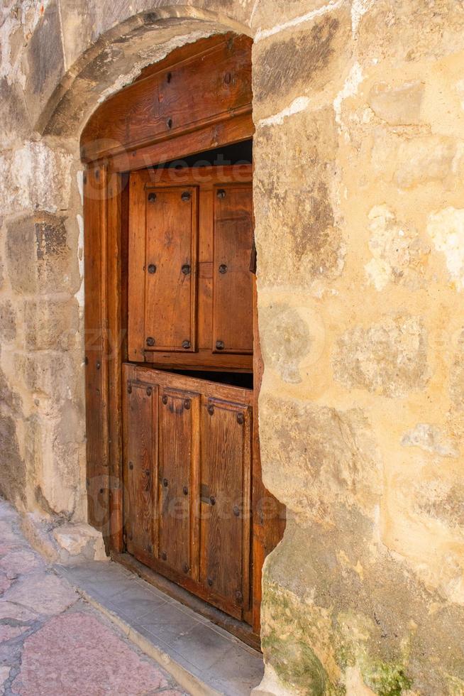 porta dupla de madeira antiga em fachada de pedra foto