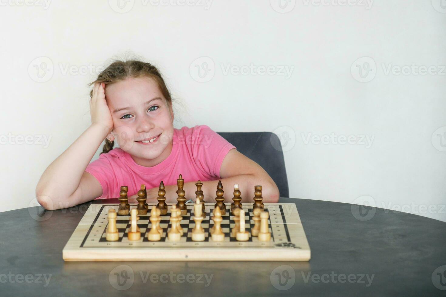 sorridente menina dentro frente do xadrez conjunto Fora para jogar foto