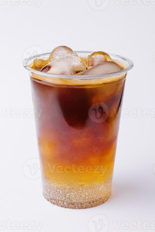 Cola com gelo dentro plástico vidro em branco fundo foto