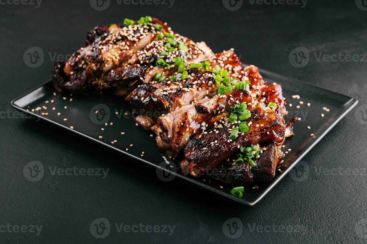 fatiado churrasco carne de porco costelas em Preto prato foto