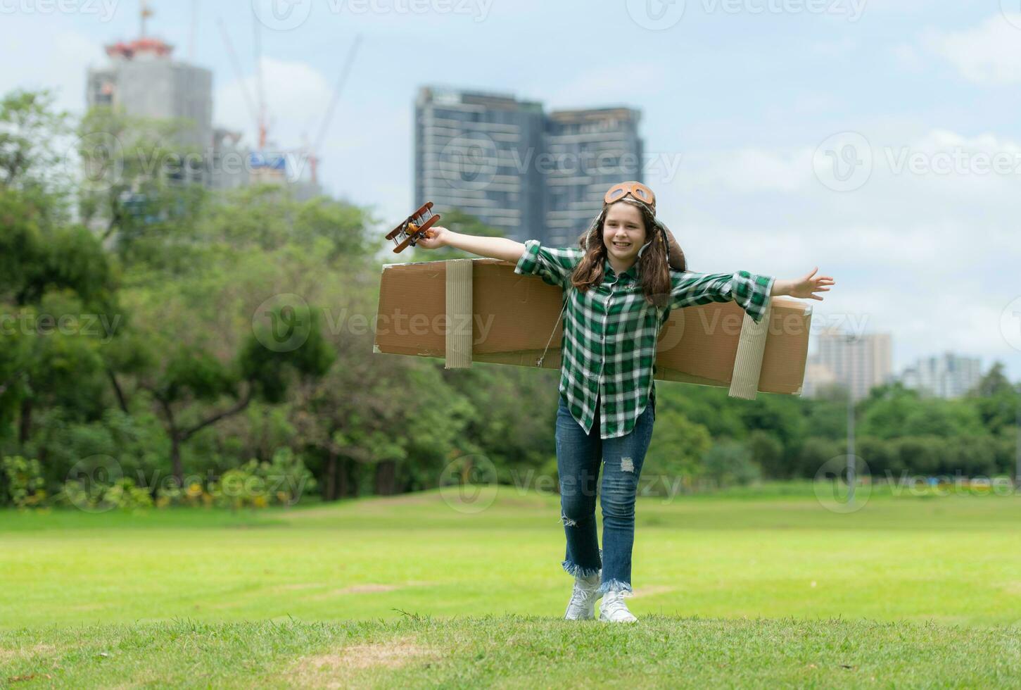 uma pequeno menina em período de férias às a parque com uma piloto equipamento e vôo equipamento. corre por aí e ter Diversão com dela sonhos. foto