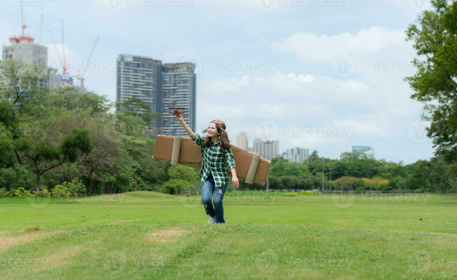 uma pequeno menina em período de férias às a parque com uma piloto equipamento e vôo equipamento. corre por aí e ter Diversão com dela sonhos. foto