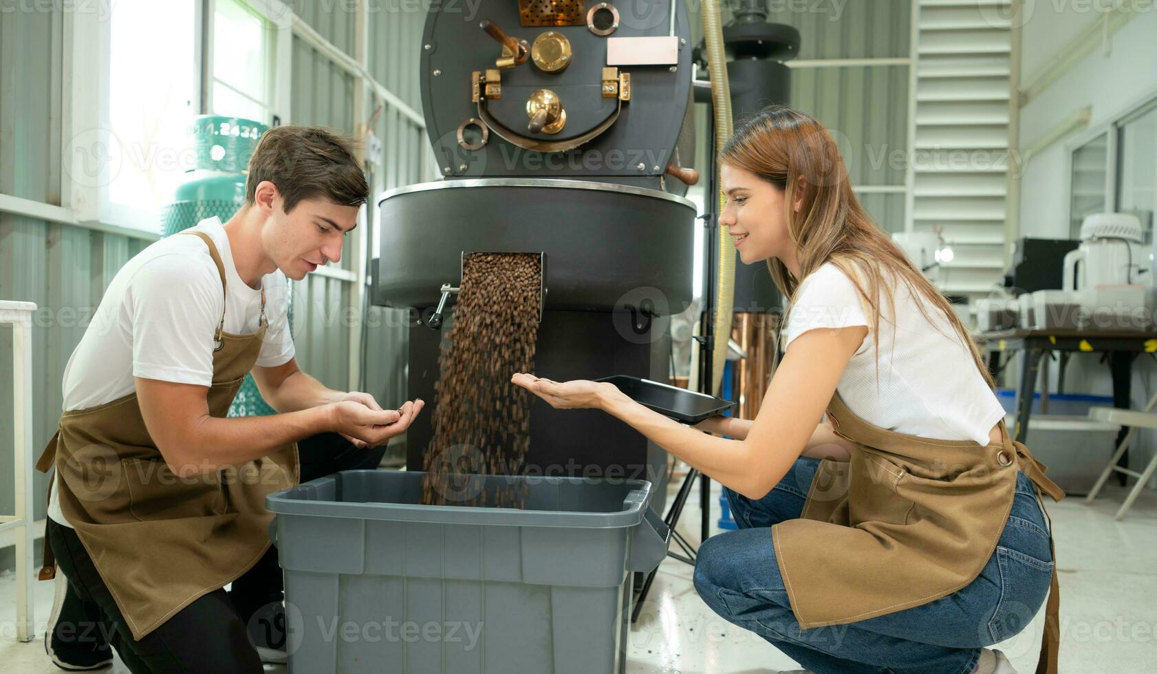 jovem homem e mulher trabalhando dentro café feijões torrador, elas estão verificação do café feijões assado. foto