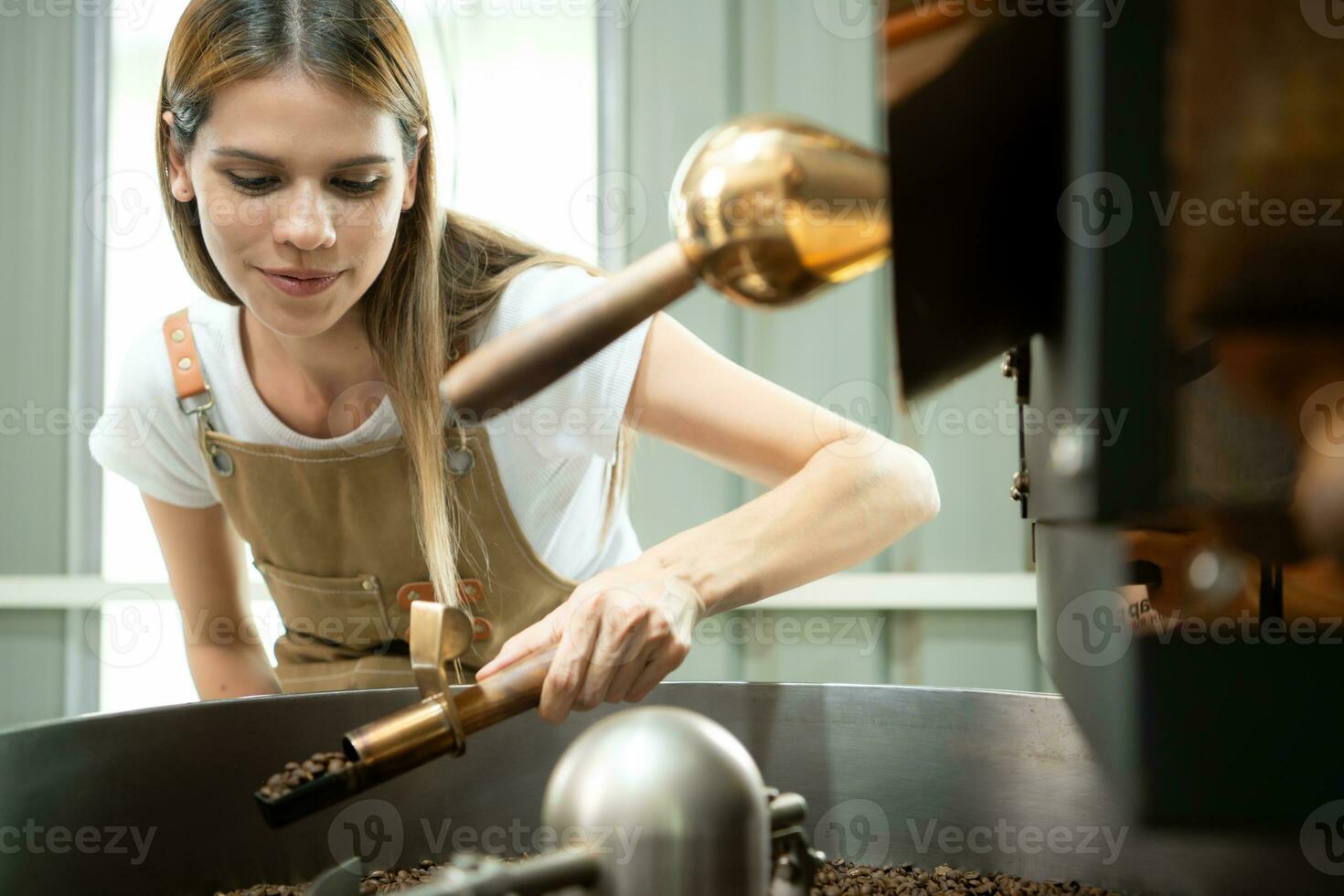 retrato do uma jovem mulher trabalhando com uma café torrador máquina foto