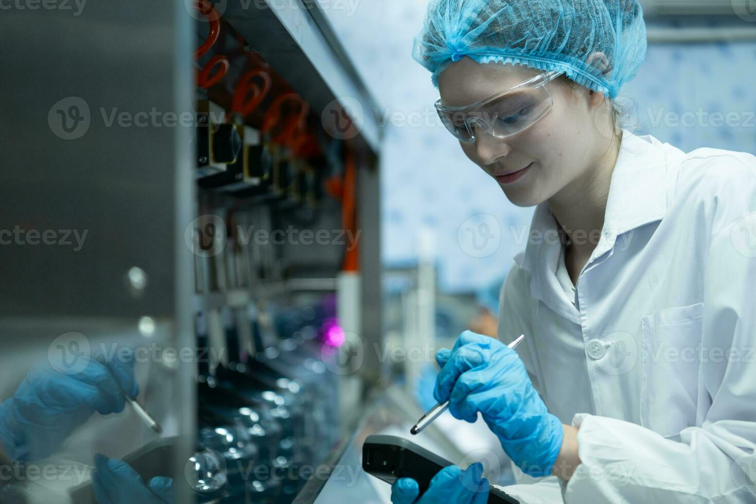 fêmea cientista dentro branco casaco e azul chapéu trabalhando dentro a ao controle máquina do Produção linha. foto