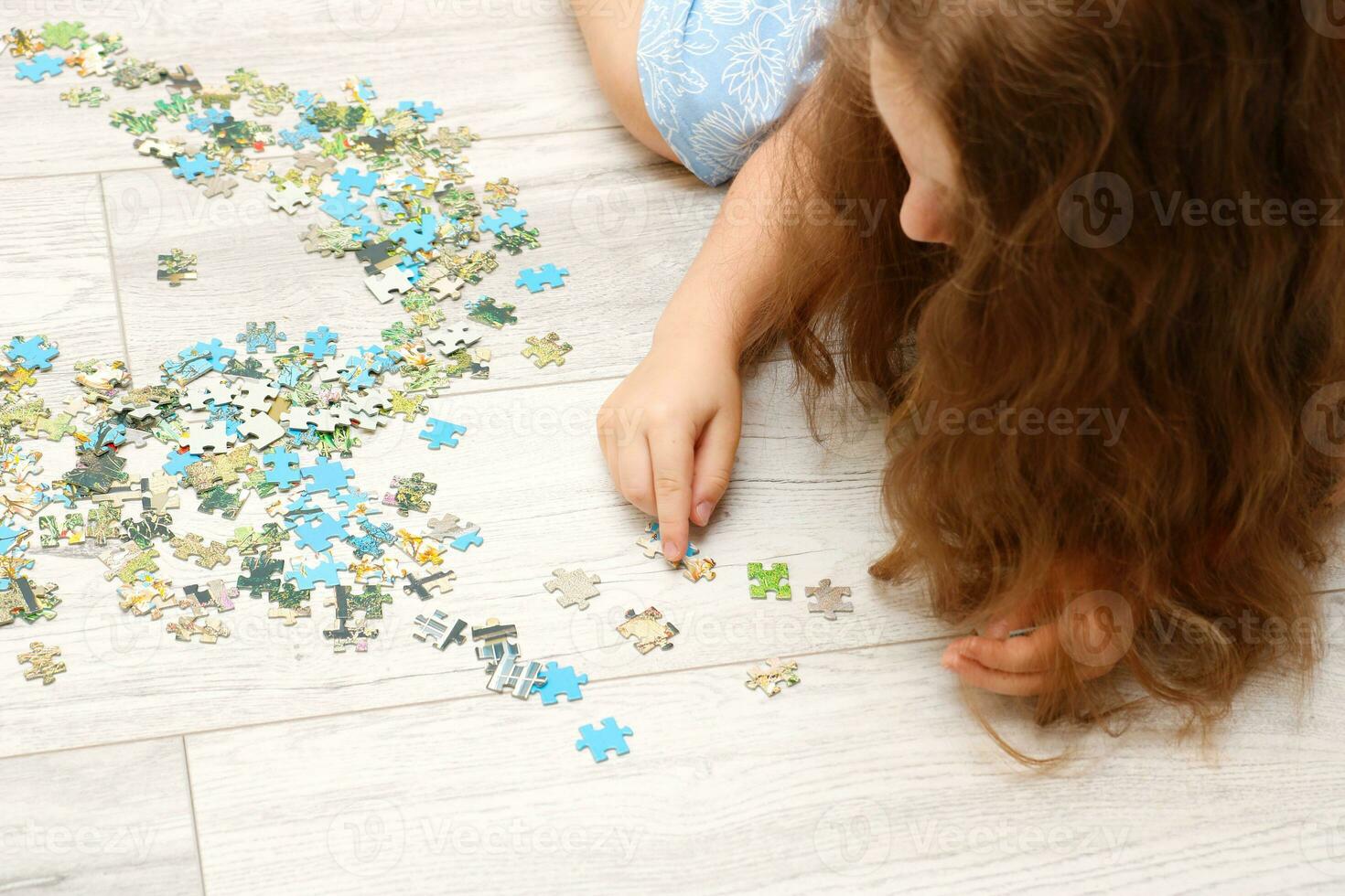 menina coleta uma enigma a partir de pequeno peças foto