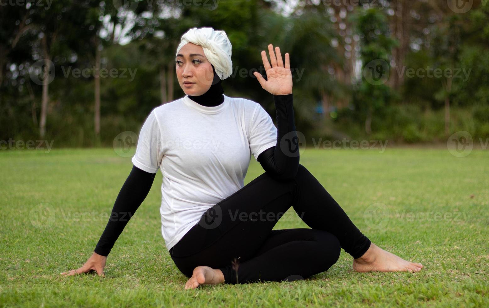 mulher agradável em hijab e roupas esportivas, fazendo ioga e alongamento. foto