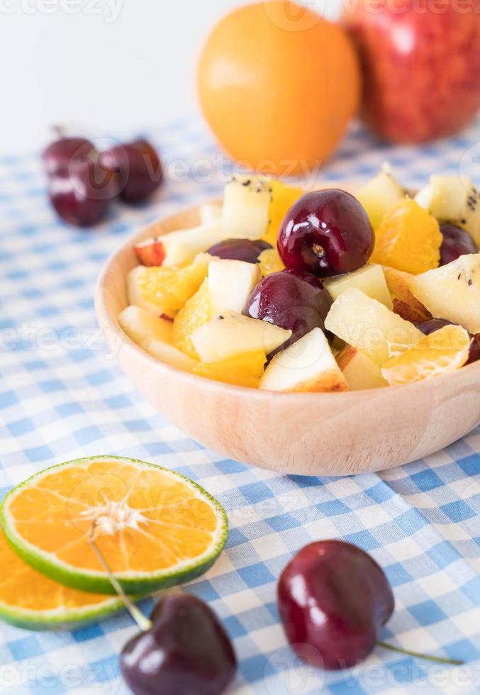 Misto de frutas fatiadas em prato de madeira foto