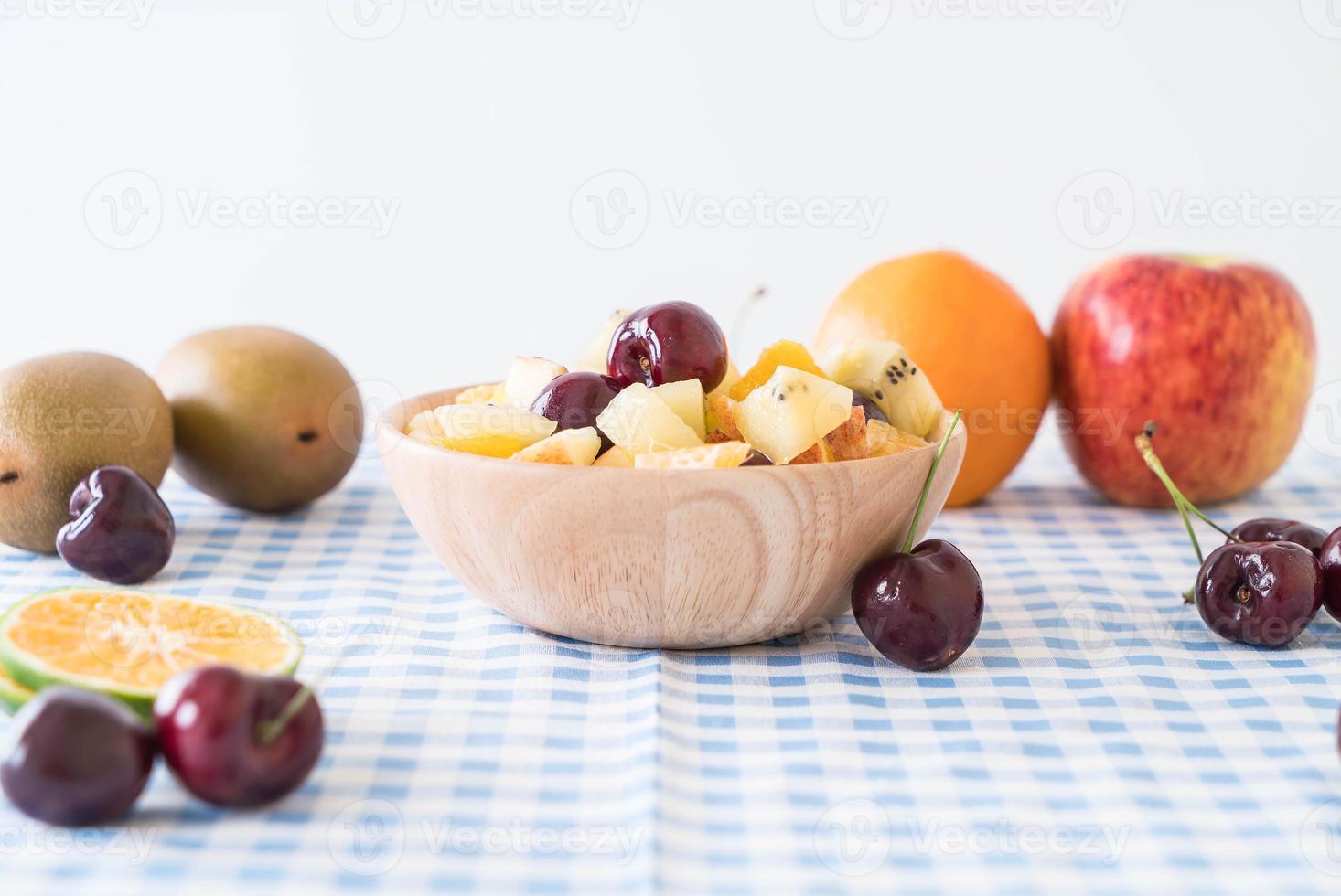 Misto de frutas fatiadas em prato de madeira foto