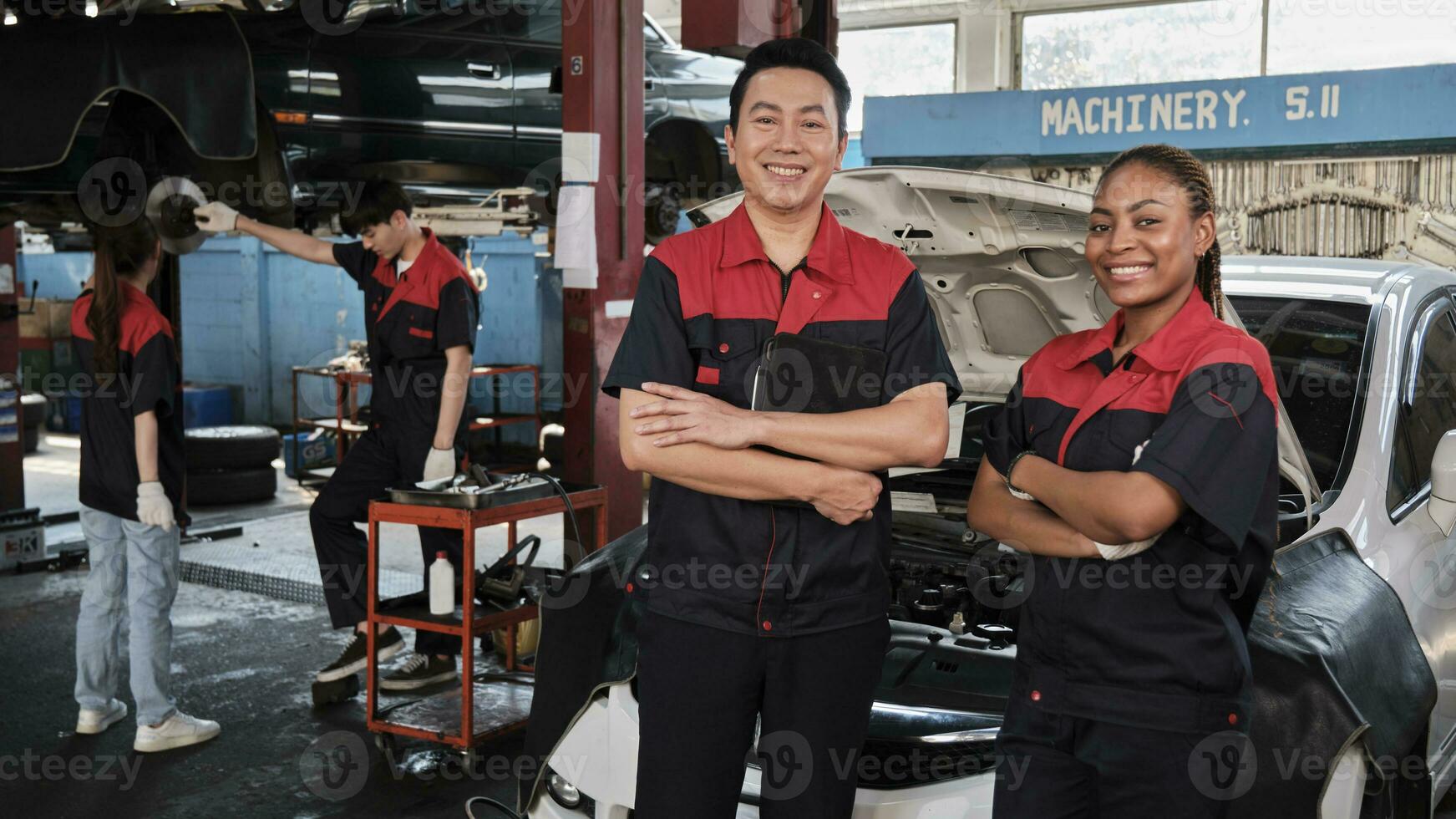 retrato do profissional mecânico parceiros braços cruzado e Veja às Câmera, trabalhos às carro serviço garagem, feliz manutenção empregos, Verifica e reparar engenheiro ocupação dentro automotivo indústria negócios. foto